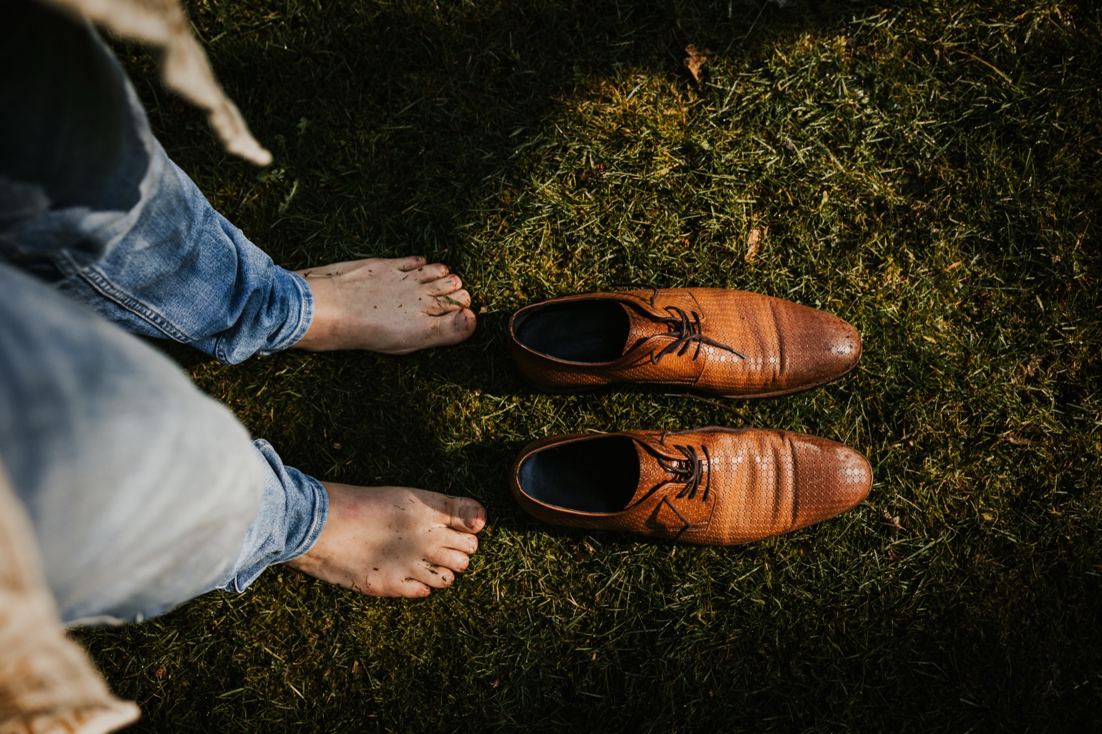 Blote voeten op het mos naast een paar schoenen