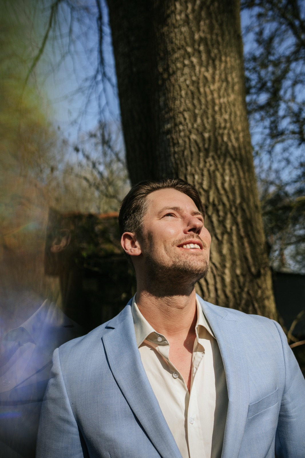 Gijs van Marion kijkt omhoog naar het licht tussen de bomen